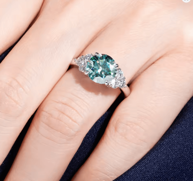 3 carat green moissanite engagement ring with VVS clarity displayed on hand, made by russmoon
