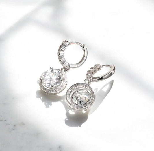 Round hoop moissanite earrings with 925 sterling silver showcased on a white marble countertop, elegant and timeless, made by russmoonco