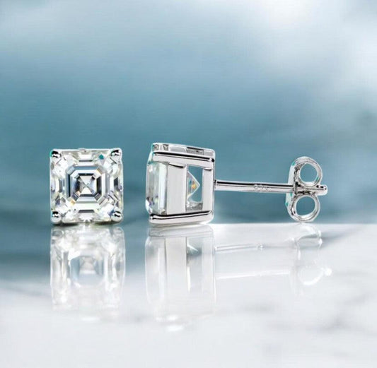 Square cut stud moissanite earrings made for both teen girls and women, displayed on a white marble counter with light blue hues, made by russmoonco
