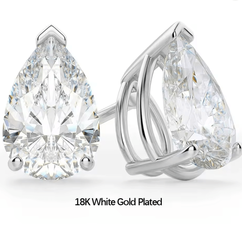 Waterdrop moissanite earrings with 925 silver showcased on a marble countertop with a light sandy vibe, made by russmoonco